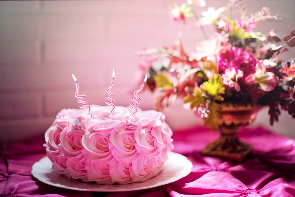 A pink birthday cake covered in sprinkles
